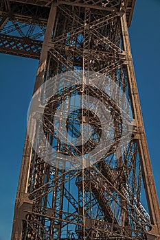 View of one legÃ¢â¬â¢s iron structure of the Eiffel Tower, with sunny blue sky in Paris. photo